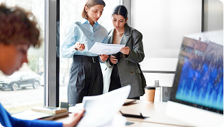 Dos chicas jóvenes mirando un papel con un gráfico