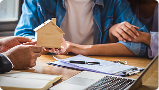 Pareja de jóvenes mirando la maqueta de una casa