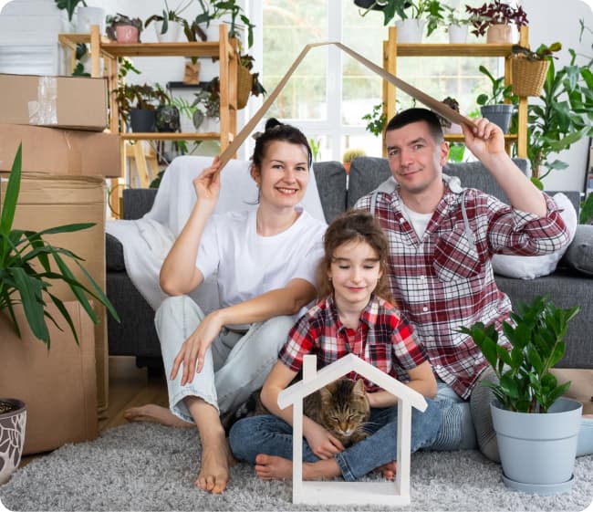 Familia que ha hecho una mudanza sentada en el suelo de su nuevo salón