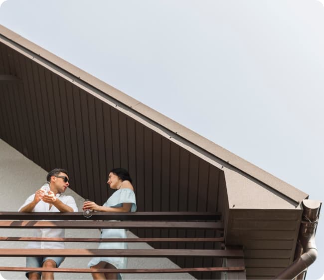 Mujer y hombre tomando algo en la terraza de una casa